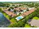 Aerial image of homes near a lake with a community pool, highlighting recreational amenities and natural surroundings at 3404 Village Green Ct, St Cloud, FL 34772