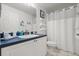 Bright bathroom featuring a blue-topped vanity, updated fixtures, and a shower with a white curtain at 3404 Village Green Ct, St Cloud, FL 34772