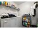 Functional laundry room with washer, dryer, and shelving for organized storage at 3404 Village Green Ct, St Cloud, FL 34772