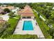 Aerial view of community pool, featuring pristine blue water, lounge chairs, and an adjacent covered patio with seating at 3404 Village Green Ct, St Cloud, FL 34772