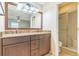 Bathroom with a double sink vanity, granite countertop, large mirror, and access to a glass-enclosed shower at 403 Broadview Ave, Altamonte Springs, FL 32701