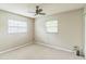 Neutral colored bedroom with two windows, ceiling fan, and carpeted floors at 403 Broadview Ave, Altamonte Springs, FL 32701