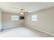 A carpeted bedroom featuring a ceiling fan, two windows, and a wall-mounted television at 403 Broadview Ave, Altamonte Springs, FL 32701