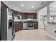 Modern kitchen featuring stainless steel appliances and granite countertops with dark wood cabinets at 4385 Wardell Pl # 13, Orlando, FL 32814