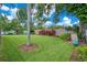 Spacious backyard with a neatly manicured lawn, privacy fence, and mature shade trees has a playground at 4390 Carolwood St, Orlando, FL 32812