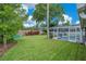 Wide shot of the home's backyard with green lawn and pool, as well as several Adirondack chairs at 4390 Carolwood St, Orlando, FL 32812