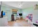 Light and airy bedroom is staged as an office and features light-colored wood floors and a ceiling fan at 4390 Carolwood St, Orlando, FL 32812
