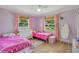 Bright bedroom with two beds, natural light, and pastel pink accents at 4390 Carolwood St, Orlando, FL 32812