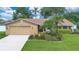 Charming single-story home featuring a two-car garage, well-manicured lawn, and lush landscaping at 4390 Carolwood St, Orlando, FL 32812