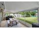 Covered patio with a wood picnic table overlooks a well-manicured lawn and lush landscaping at 4390 Carolwood St, Orlando, FL 32812