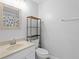 Practical bathroom with a vanity, shelving above the toilet, and a framed mirror at 446 Arkansas Ct, Poinciana, FL 34759