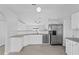 Bright kitchen with stainless steel appliances, granite countertops, and white cabinets at 446 Arkansas Ct, Poinciana, FL 34759