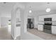 Modern kitchen with stainless steel appliances and sleek white cabinets and granite countertop at 446 Arkansas Ct, Poinciana, FL 34759