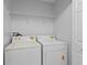 A dedicated laundry room with a washer, dryer, and wire shelving for storage at 446 Arkansas Ct, Poinciana, FL 34759