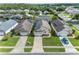 Aerial view of homes with well-maintained lawns, driveways, solar panels and community tennis courts at 4533 Oakbrook Ct, Kissimmee, FL 34746