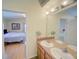 Bright bathroom featuring a double sink vanity and a view into the bedroom at 456 Old Bridge Cir, Davenport, FL 33897