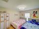 Bright bedroom featuring two beds, playful decor, and a window at 456 Old Bridge Cir, Davenport, FL 33897