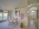 Dining room area leading to entryway with glass table, white chairs, and stylish decor at 456 Old Bridge Cir, Davenport, FL 33897