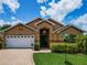 Charming single-Gathering home with a well-manicured lawn, brick driveway, and beautiful landscaping at 456 Old Bridge Cir, Davenport, FL 33897