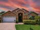 Charming single-Gathering home with a well-manicured lawn, brick driveway, and beautiful landscaping at 456 Old Bridge Cir, Davenport, FL 33897