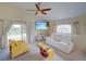 Comfortable living room with modern furniture, bright windows, and a ceiling fan at 456 Old Bridge Cir, Davenport, FL 33897