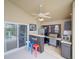 Covered outdoor kitchen area featuring a grill, bar, mini-fridge, and fan at 456 Old Bridge Cir, Davenport, FL 33897