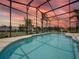 A beautiful, screened-in pool with a serene backyard view, perfect for relaxation and entertaining at 456 Old Bridge Cir, Davenport, FL 33897