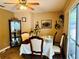 The dining room has a table set for a meal, a corner cabinet and a sliding glass door, and the room is illuminated by natural light at 46 Carriage Hill Cir, Casselberry, FL 32707