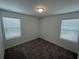 Neutral bedroom with a cozy carpet, two windows, and a minimalist design, creating a serene atmosphere at 477 Madison Dr, Davenport, FL 33837