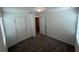 A clean, carpeted bedroom with two doors and a window, offering a simple and inviting space at 477 Madison Dr, Davenport, FL 33837