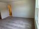 Spacious carpeted bedroom with neutral walls, a window, and a door leading to an en-suite bathroom at 477 Madison Dr, Davenport, FL 33837