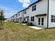 Row of modern townhomes featuring white exteriors, black accents, and well-maintained lawns in a sunny setting at 477 Madison Dr, Davenport, FL 33837