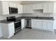 A bright kitchen features stainless steel appliances, granite counters, and white cabinets at 477 Madison Dr, Davenport, FL 33837