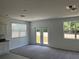 Living room boasts natural light, neutral walls, grey carpet, and access to the outdoors at 477 Madison Dr, Davenport, FL 33837