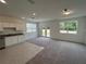 Open-concept living space with a kitchen, living room, carpeted floors, and natural light from the windows at 477 Madison Dr, Davenport, FL 33837