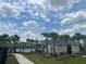 Community pool surrounded by palm trees, manicured lawns, and a charming clubhouse at 477 Madison Dr, Davenport, FL 33837