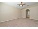 Spacious bedroom with neutral carpeting, a ceiling fan, and an arched doorway to the bathroom at 492 Lanarkshire Pl, Apopka, FL 32712
