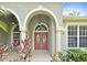 Inviting arched entryway featuring a double door with glass accents and well-maintained landscaping at 492 Lanarkshire Pl, Apopka, FL 32712