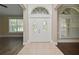 Elegant foyer showcasing a white double door with ornate glass, tiled flooring, and views of the home's interior at 492 Lanarkshire Pl, Apopka, FL 32712