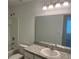 Well-lit bathroom with a shower-tub combo, a large mirror, and neutral finishes at 497 Madison Dr, Davenport, FL 33837