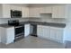 Well-lit kitchen with stainless steel appliances, granite countertops, and white cabinetry at 497 Madison Dr, Davenport, FL 33837