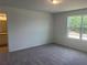 Bright main bedroom featuring plush carpeting, a large window, and an ensuite bathroom at 497 Madison Dr, Davenport, FL 33837