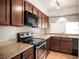 Functional kitchen with stainless steel appliances, granite countertops, and wooden cabinetry at 507 Northlake Dr # 507, Sanford, FL 32773