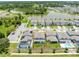 An aerial view of a property with a screened-in pool, showcasing its proximity to a lake and neighborhood at 5677 Cedar Chase Dr, St Cloud, FL 34771
