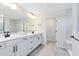 Modern bathroom with double vanity, sleek fixtures, and tile flooring leading to a walk-in shower at 5677 Cedar Chase Dr, St Cloud, FL 34771