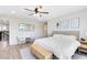 Comfortable bedroom featuring light wood floors, modern décor, a ceiling fan, and a plush white comforter at 5677 Cedar Chase Dr, St Cloud, FL 34771