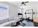 Bright bonus room featuring a ceiling fan, a gray sectional, and home fitness equipment at 5677 Cedar Chase Dr, St Cloud, FL 34771