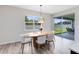 Dining area with modern oval table, stylish light fixture, and sliding doors to the backyard patio at 5677 Cedar Chase Dr, St Cloud, FL 34771