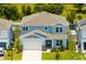 Aerial view of a two-story home with a two-car garage and well-manicured lawn at 5677 Cedar Chase Dr, St Cloud, FL 34771