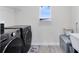 Well-lit laundry room with side-by-side washer and dryer, plus a small window at 5677 Cedar Chase Dr, St Cloud, FL 34771